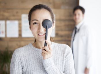 Woman covering eye during eye exam