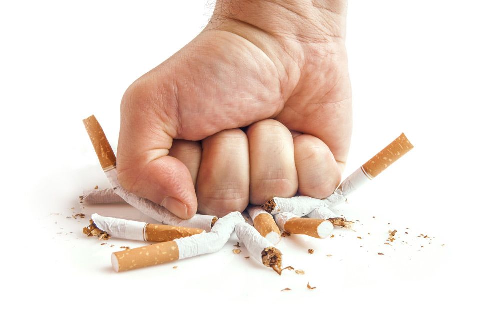 Fist crushing multiple cigarettes.