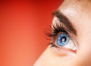 close up of woman with blue eyes suffering from eye allergies