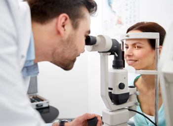 optician with tonometer and patient at eye clinic