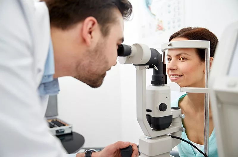 optician with tonometer and patient at eye clinic