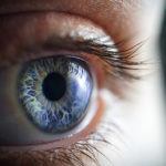 Close up or a blue eye looking off camera with a black background