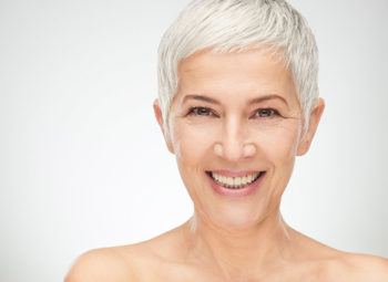 Portrait of beautiful senior woman in front of white background.