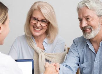 Happy senior couple meeting with doctor after cataract surgery