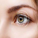 close-up of young women eyes with high tech scan imaging