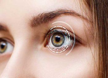 close-up of young women eyes with high tech scan imaging