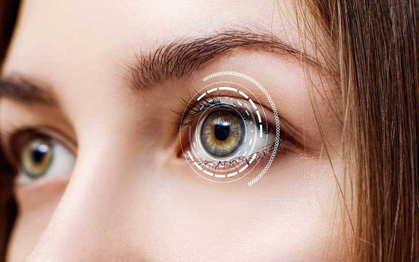 close-up of young women eyes with high tech scan imaging