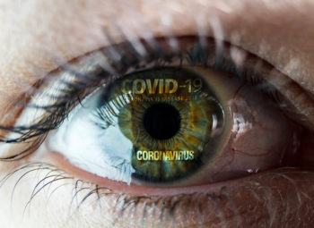 close up of eye with the worlds covid-19 and coronavirus reflected in it