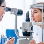 an ophthamologist or optometrist examines the eye health of a female patient