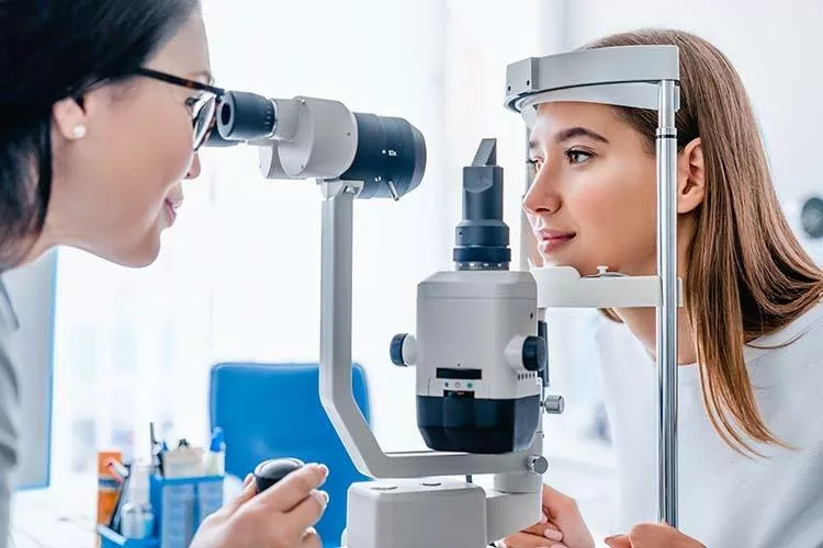 an ophthamologist or optometrist examines the eye health of a female patient