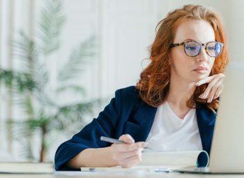 women in eyeglasses on laptop researching LASIK surgeons