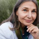 Close up portrait of attractive charming senior mature female with gray hair, blue eyes