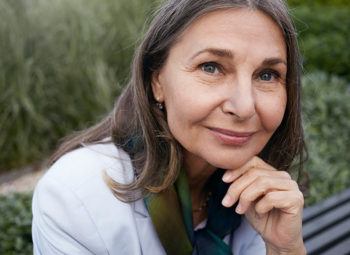 Close up portrait of attractive charming senior mature female with gray hair, blue eyes