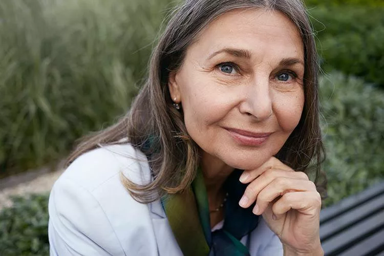 Close up portrait of attractive charming senior mature female with gray hair, blue eyes