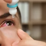 close-up of a man using eye drops