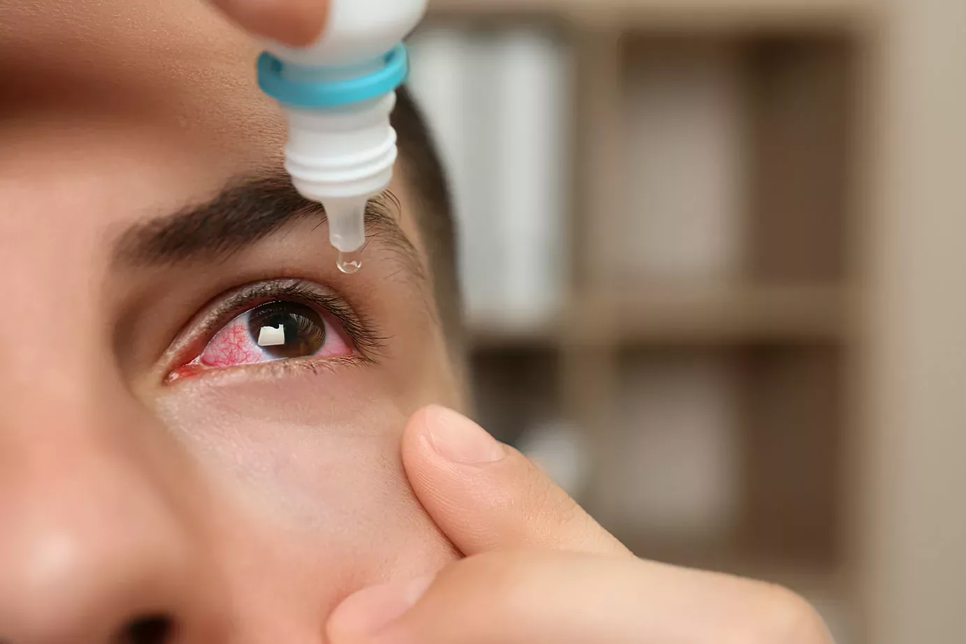 close-up of a man using eye drops