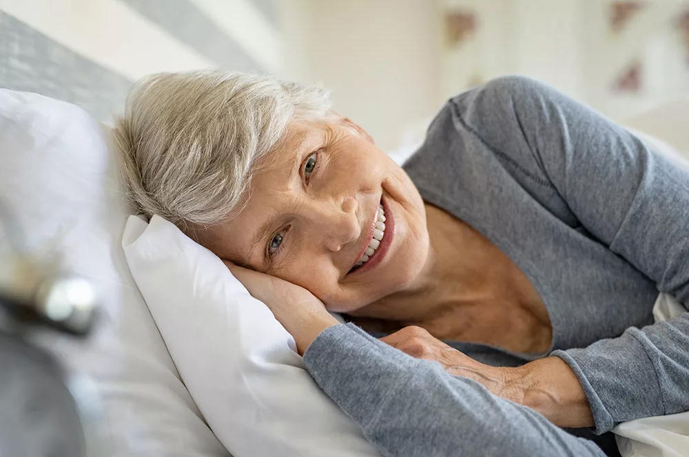 senior woman on side in bed smiling