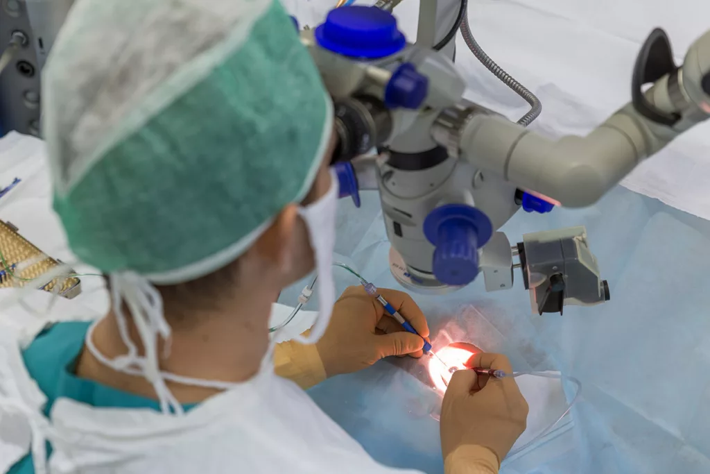 eye surgeon at work, using microscope and tools