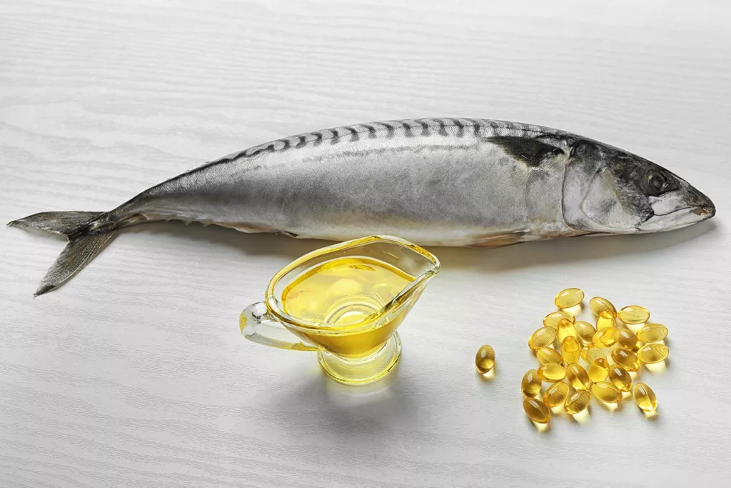 Fish on a table with OMEGA-3 Fish Oil capsules